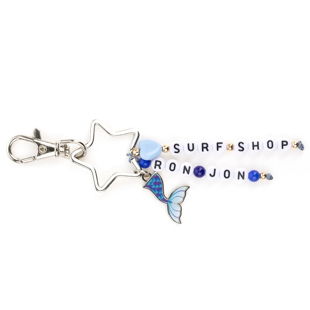 Keychain with star-shaped ring, blue mermaid tail charm, and beads spelling RON JON SURF SHOP attached to a star shaped metal ring.