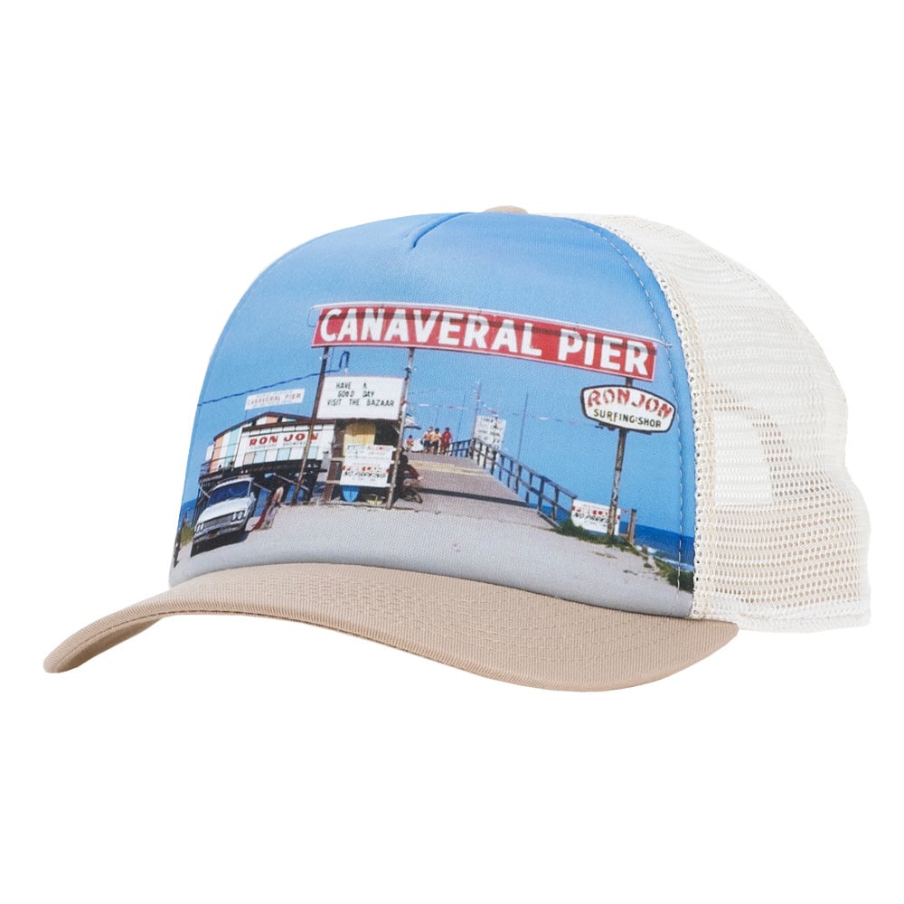 A trucker hat featuring an image of Canaveral Pier with Ron Jon signage and a pier extending into the ocean under a blue sky.