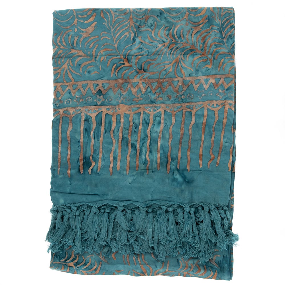 A teal and gold patterned sarong with fringe tassels along one edge, featuring abstract and geometric designs.