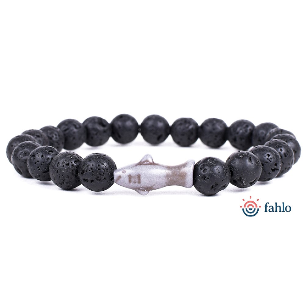 A stretch bracelet with round black lava beads and a shark-shaped bead in the center, displayed on a white background with the Fahlo logo in the corner.