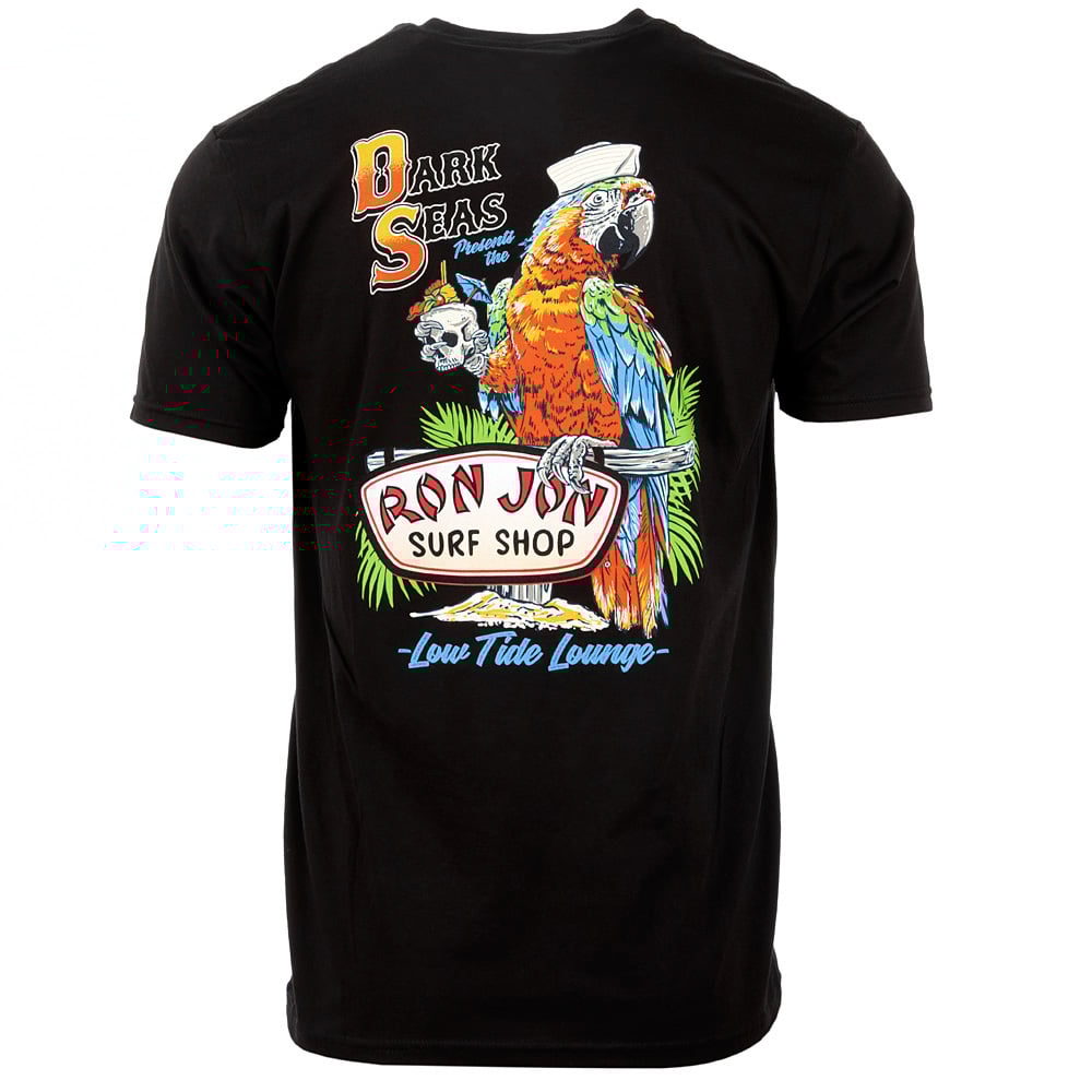 Black t-shirt featuring a colorful parrot in a sailor hat holding a Ron Jon Surf Shop sign, with palm leaves and Dark Seas text printed on the back.