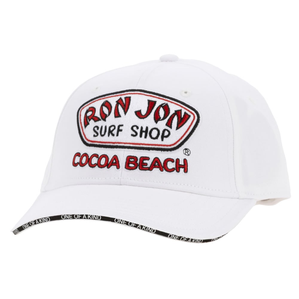 White baseball cap with Ron Jon Surf Shop Cocoa Beach embroidered on the front and One of a Kind text on the edge of the brim.
