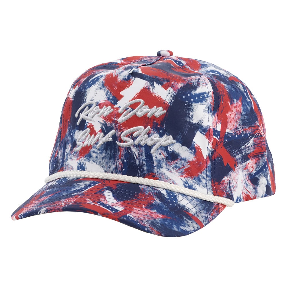 Colorful cap with abstract red, white, and blue pattern, featuring rope detail above the brim and cursive embroidery of the words Ron Jon Surf Shop on the front.