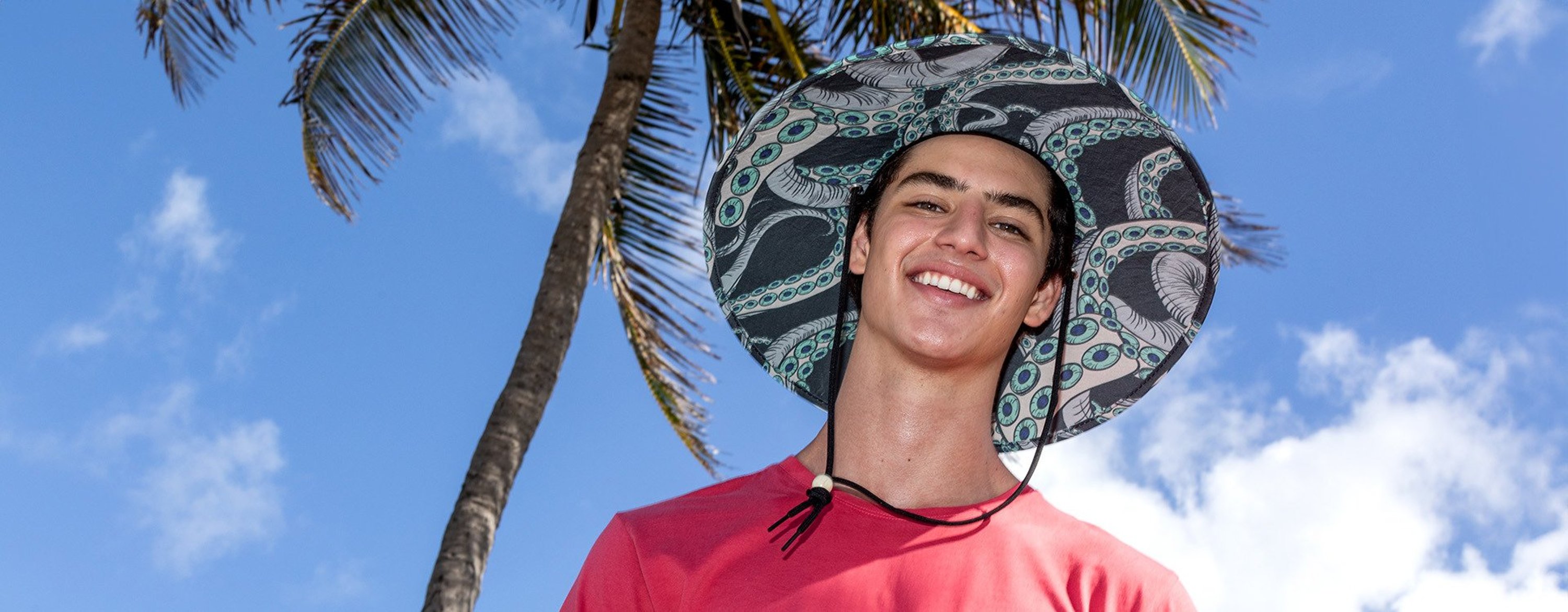 guy outdoors wearing tentacle print straw lifeguard hat