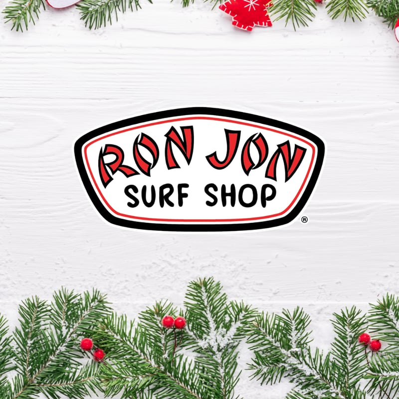 Logo of Ron Jon Surf Shop on a wooden background with pine branches and red berries.